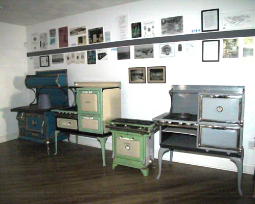 A display of vintage stoves in various colors and styles.
